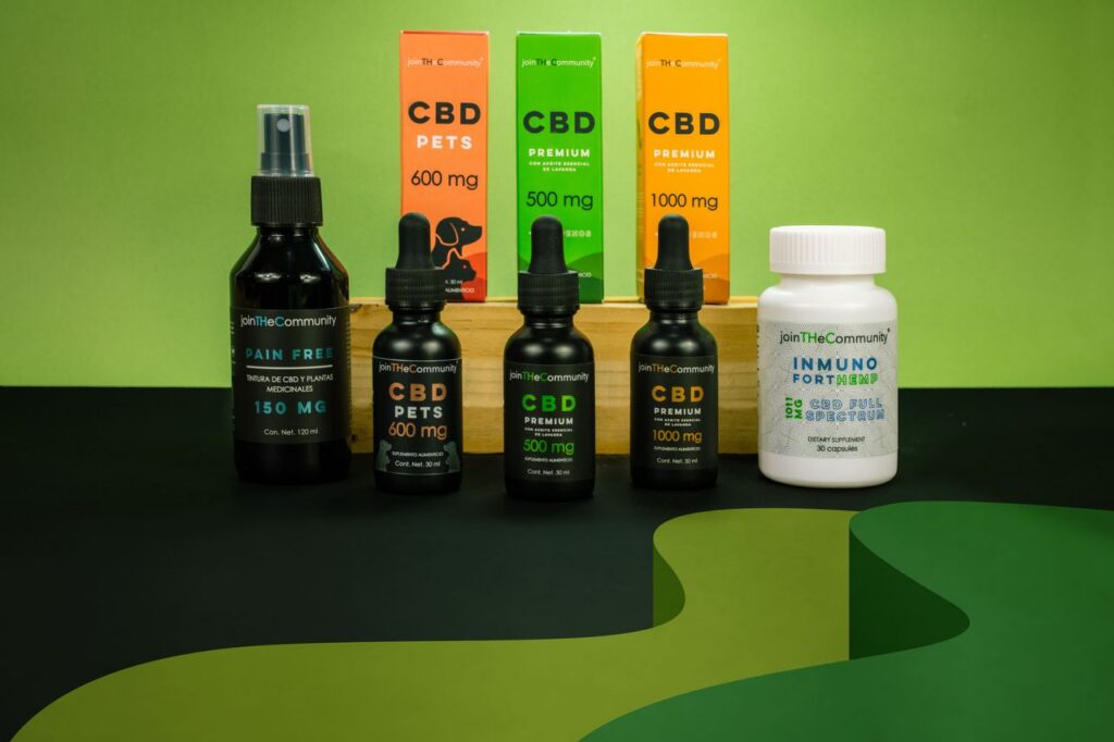 Array of CBD products including oils and supplements on a green background.