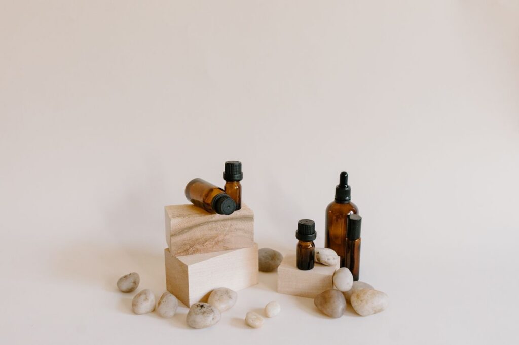 Still life composition of essential oil bottles with stones on a neutral background.